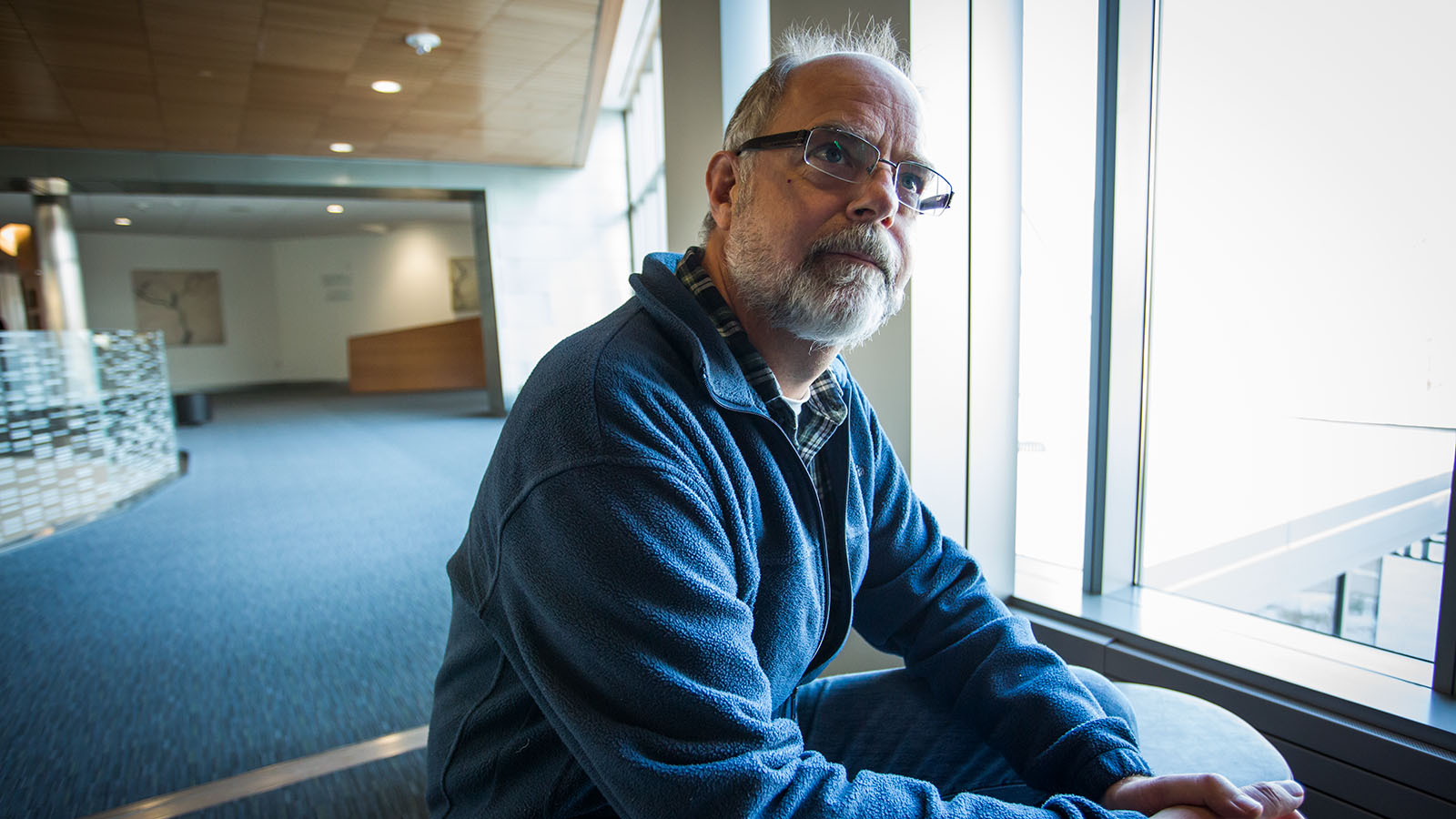 An environmental portrait of JAX's Bill Skarnes gazing out the window