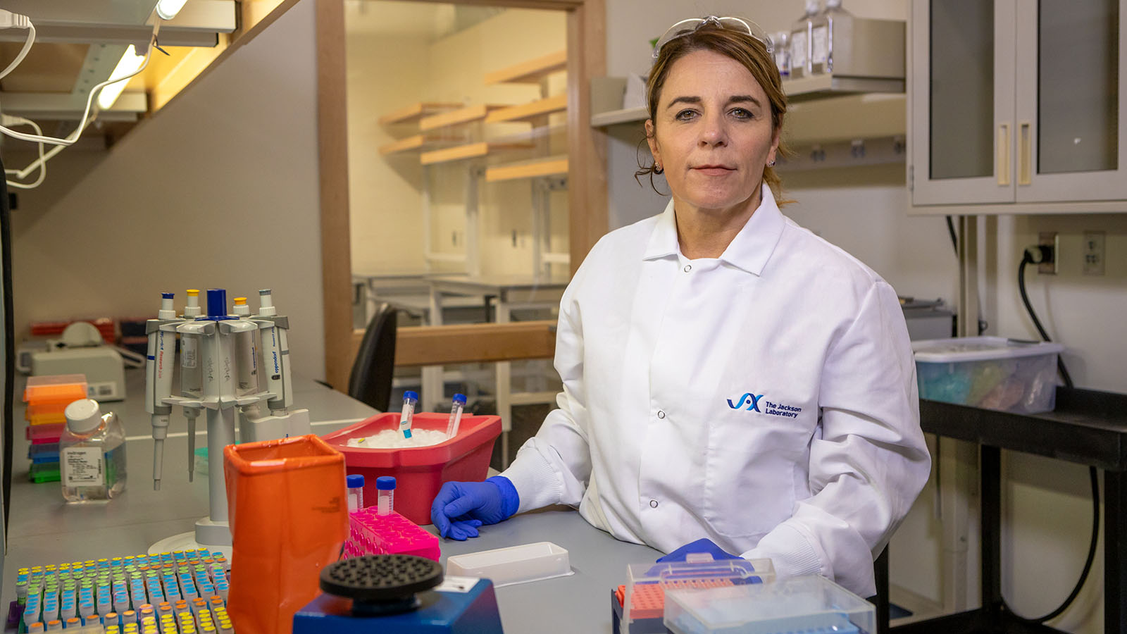 The Jackson Laboratory's Cat Lutz in her lab standing at a bench. Photo credit: Tiffany Laufer